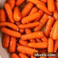 A final presentation image of Honey Brown Sugar Glazed Carrots in a rustic white bowl, ready to be served.