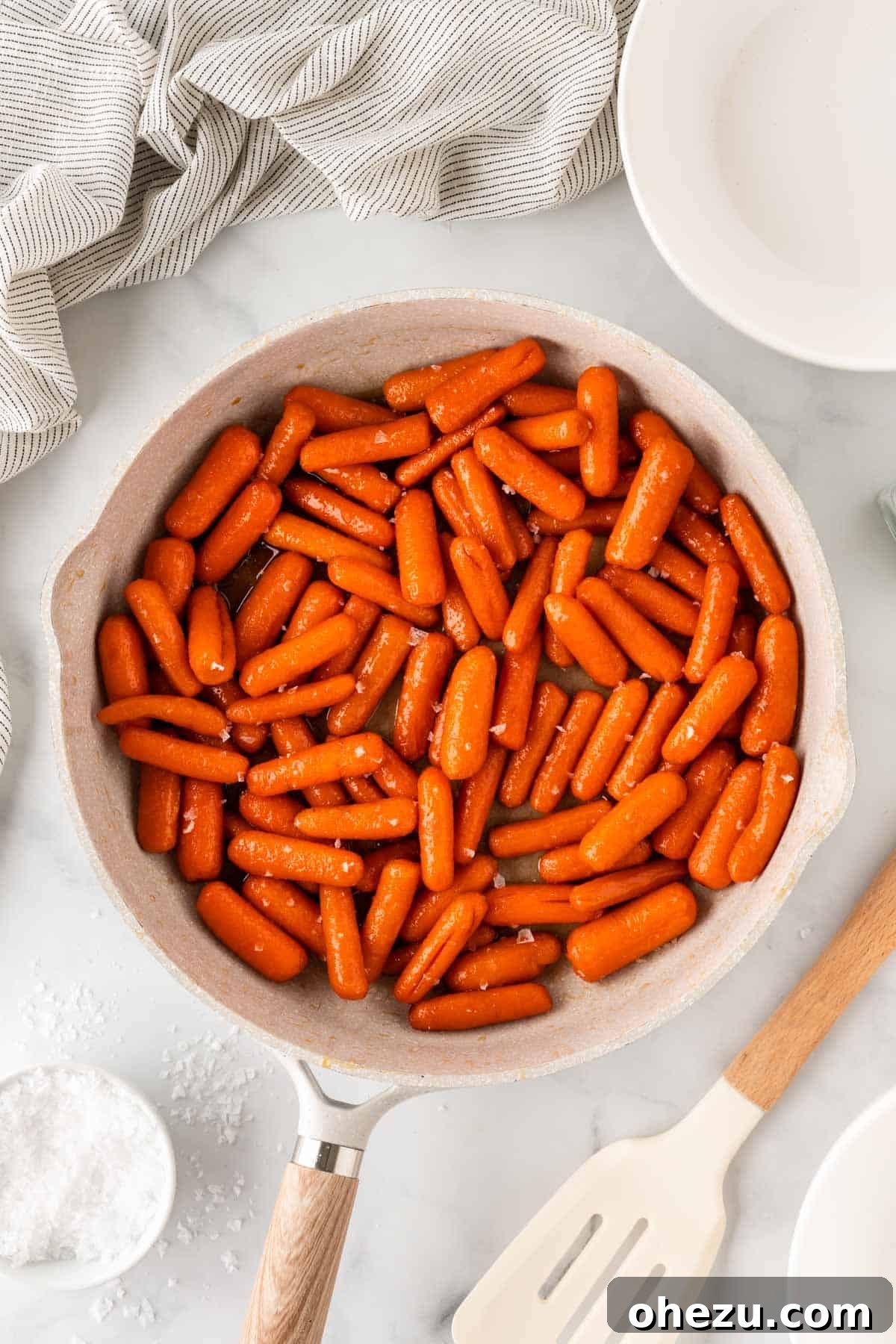 A bowl of freshly cooked Honey Brown Sugar Glazed Carrots, steam gently rising, ready to be enjoyed.
