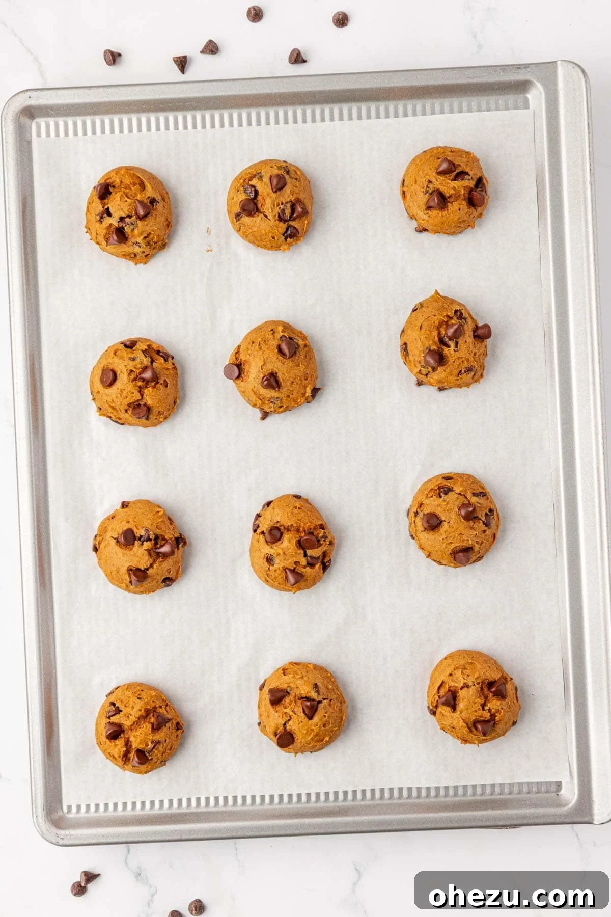 Freshly baked cake mix pumpkin cookies on a baking sheet, golden brown and perfectly cooked.