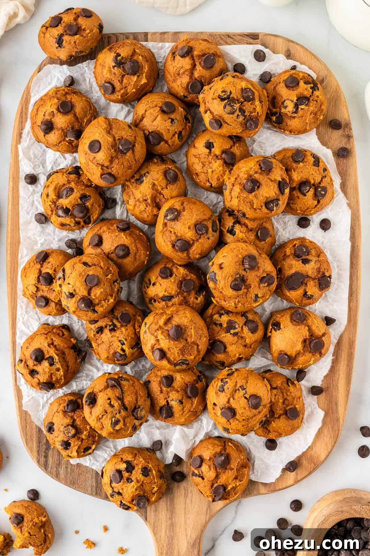 Cake mix pumpkin cookies artfully arranged on a rustic wooden cutting board, inviting a taste of autumn.
