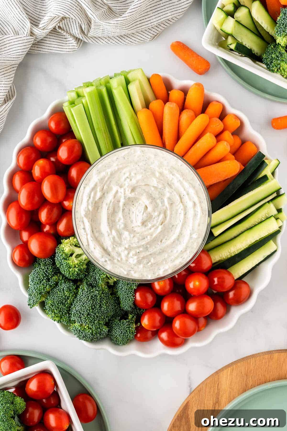 Garden Fresh Dip 10 Another appealing shot of the veggie dip in a bowl, artfully arranged with a colorful assortment of fresh broccoli, cherry tomatoes, celery, and baby carrots around it, ready for a healthy snack or appetizer.