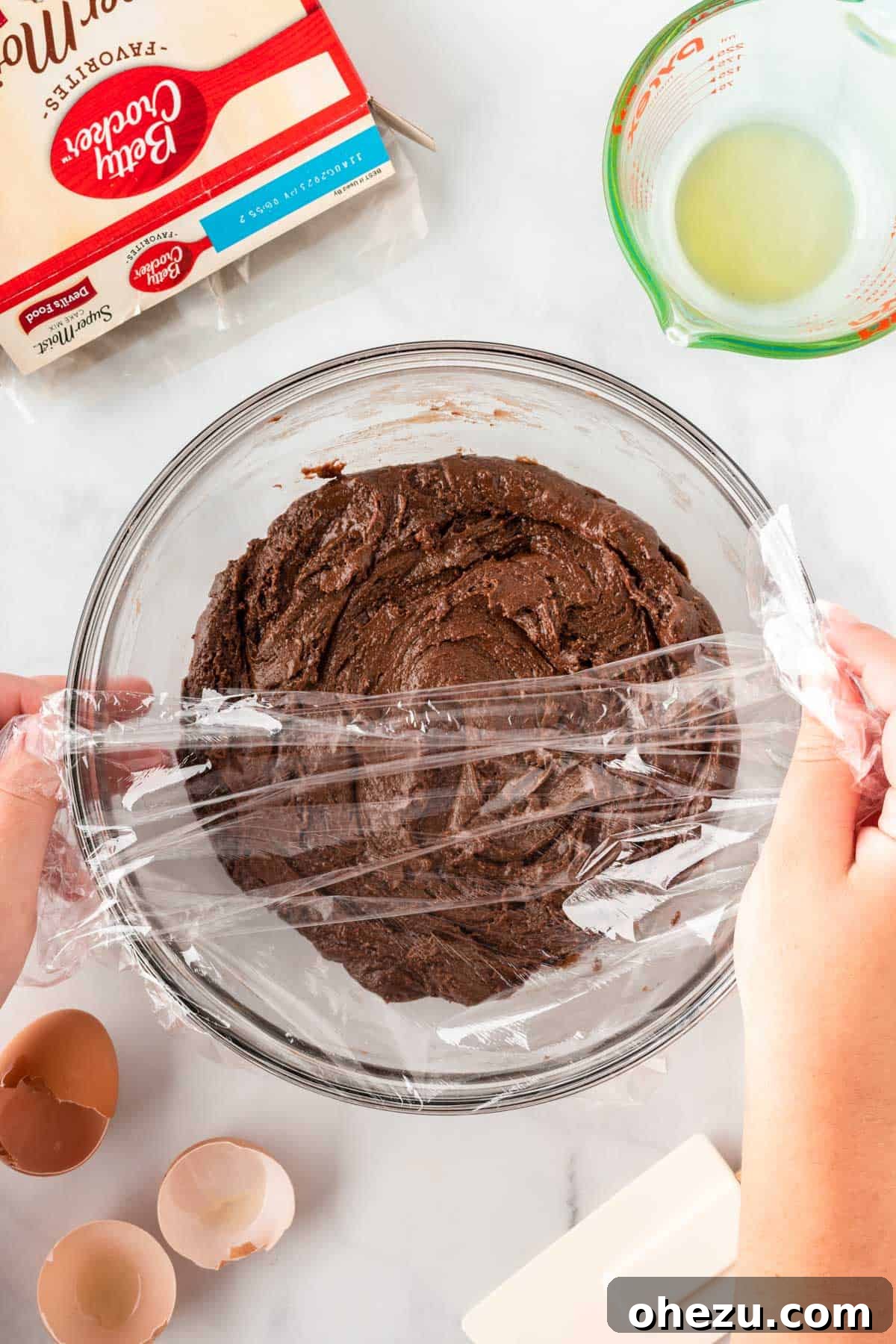 Bowl of cookie dough covered with plastic wrap for chilling