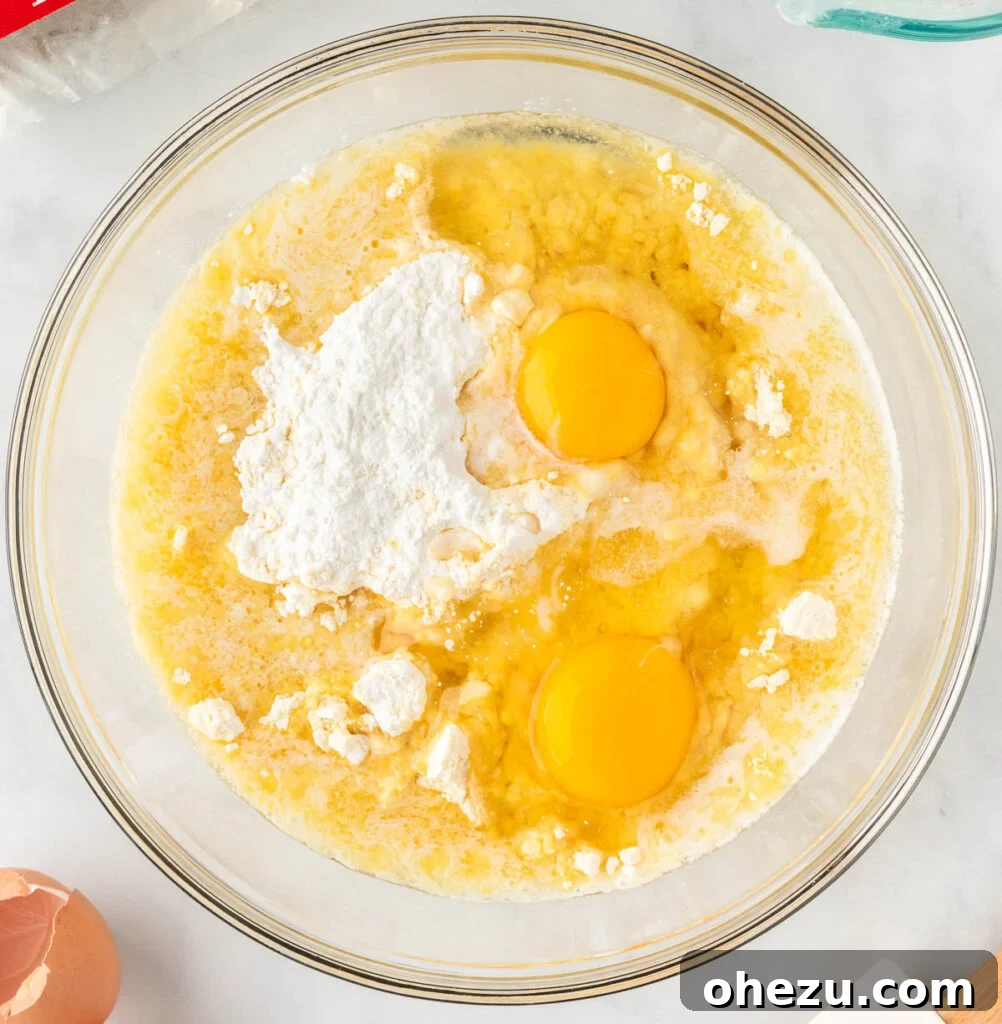 adding eggs and melted butter to the cake mix