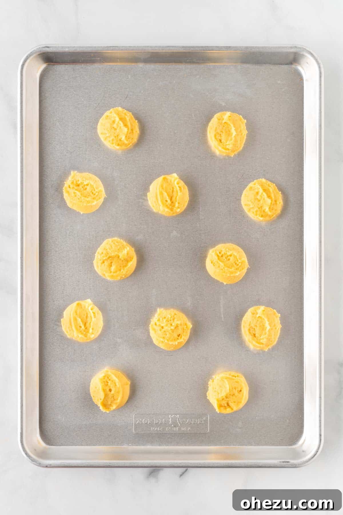 sugar cookie dough balls arranged on a baking sheet