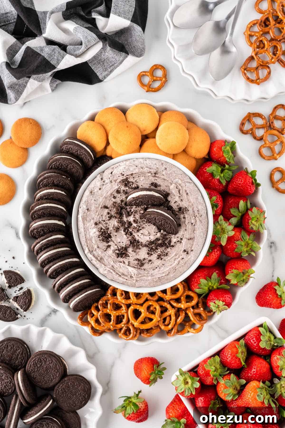 Oreo Dream Dip 13 A full platter showcasing the Oreo Dip surrounded by a variety of dippers including Nilla Wafers, whole Oreos, strawberries, and pretzels, set against a festive background.
