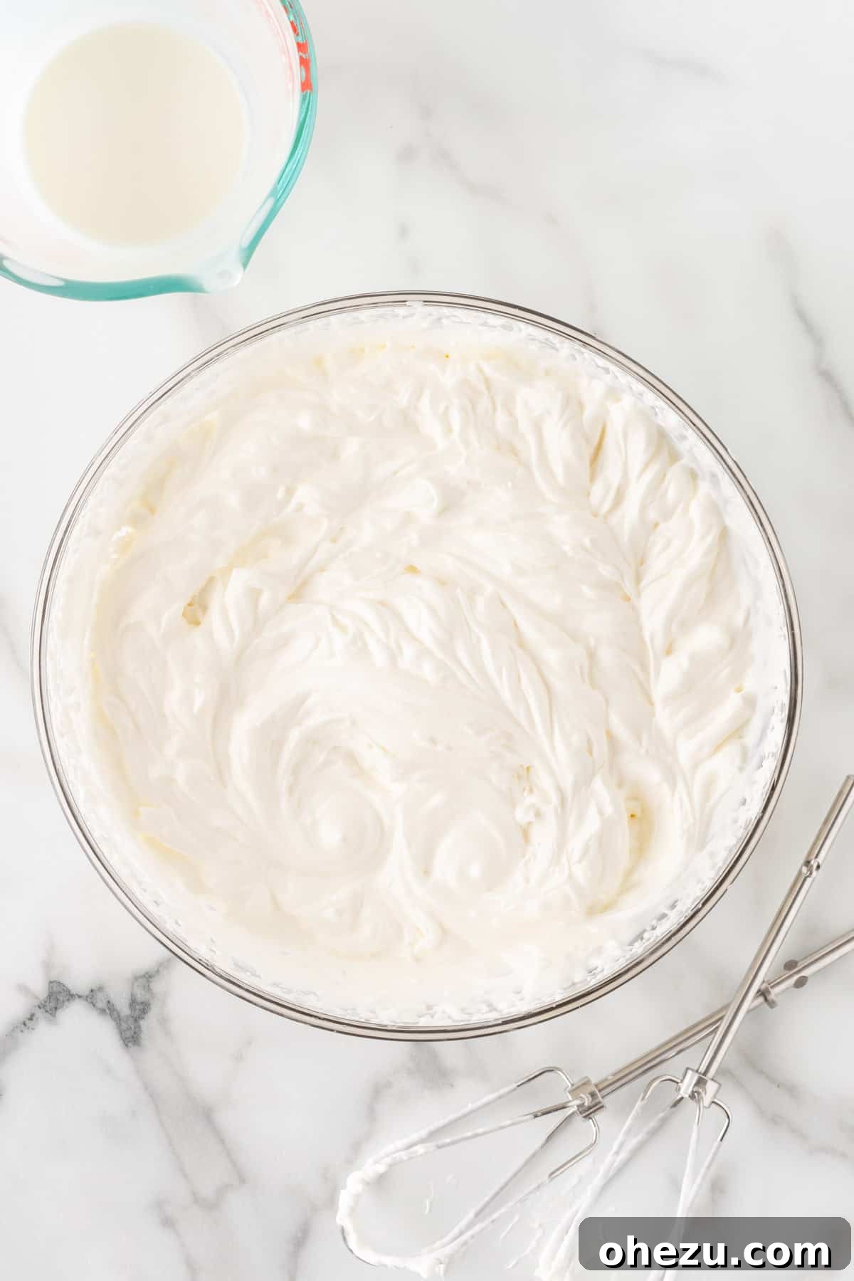 Oreo Dream Dip 6 Fluffy homemade whipped cream in a mixing bowl, showing stiff peaks