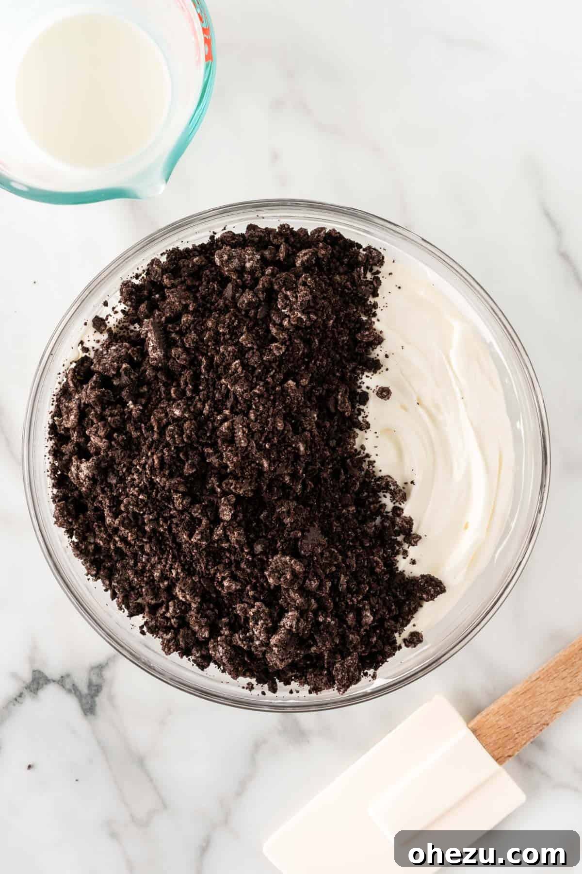 Oreo Dream Dip 7 Crushed Oreo pieces being added to the cream cheese and whipped cream mixture