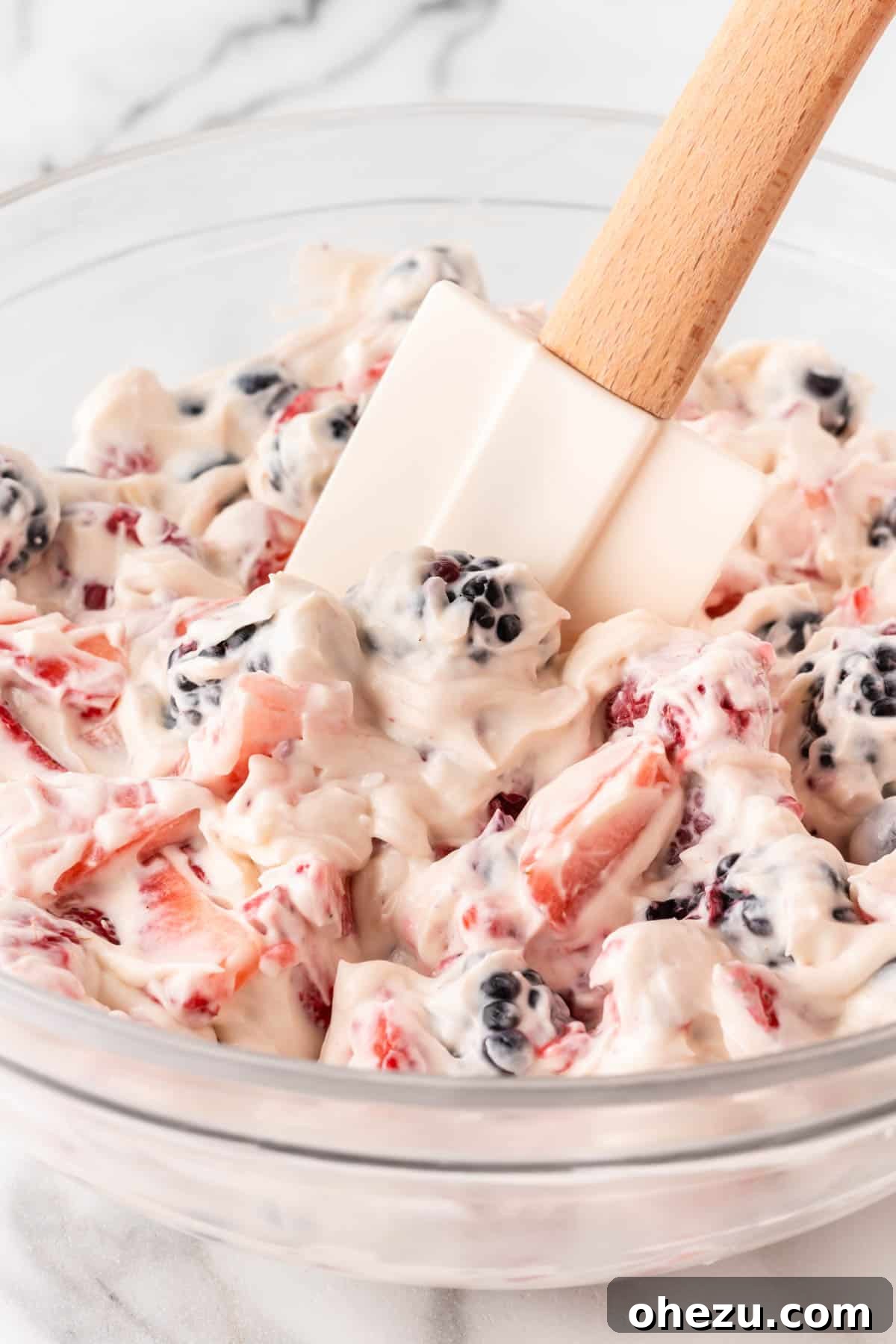 The mixed berry cheesecake salad in a large serving bowl, with the creamy filling and colorful berries beautifully combined.