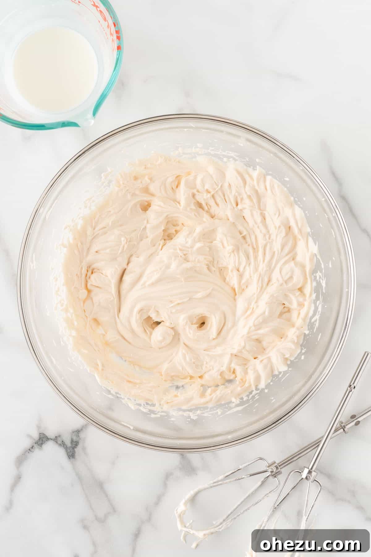 A bowl of perfectly whipped homemade cream with stiff peaks, sweet and aromatic with vanilla.