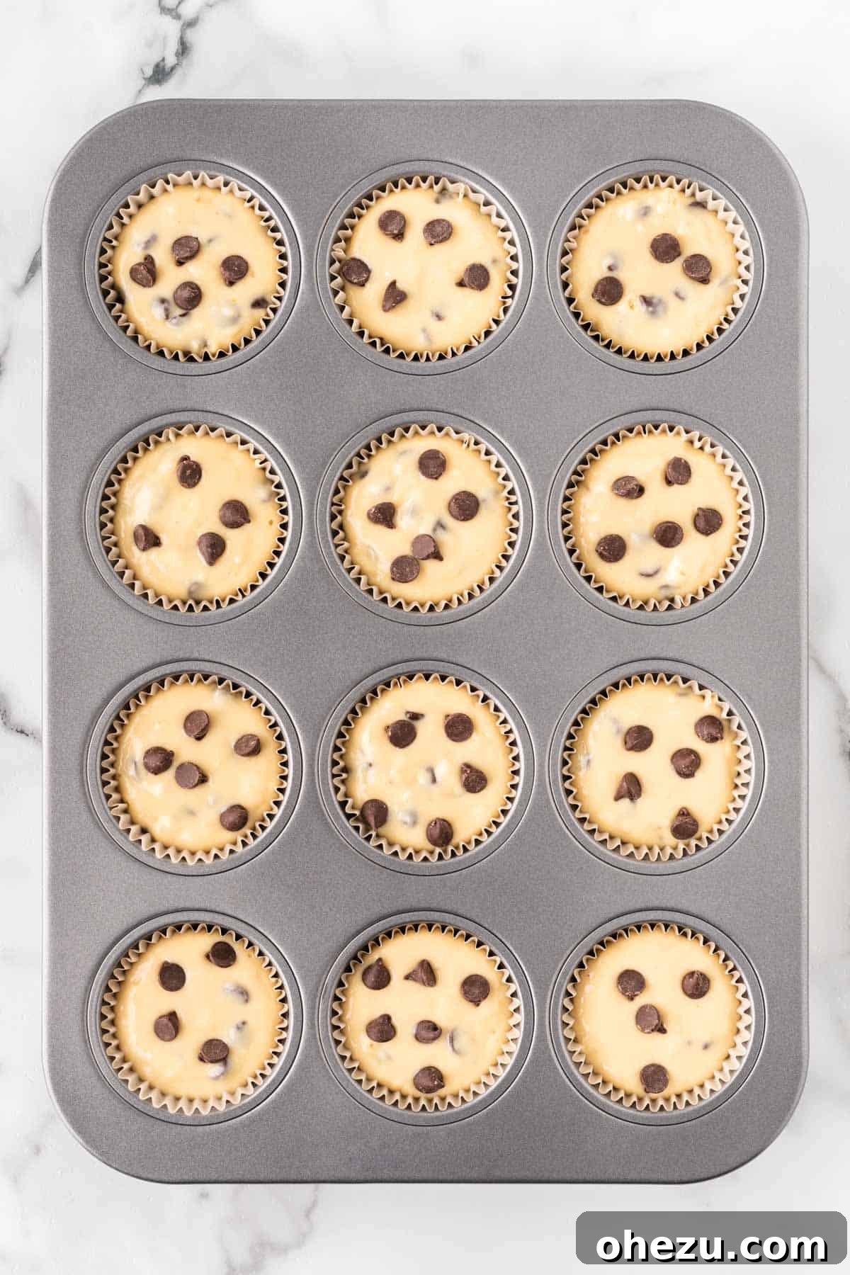 Irresistible Bakery Chocolate Chip Muffins 12 muffin tin filled with batter