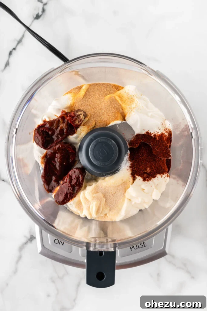 All ingredients for chipotle ranch dressing placed inside a food processor, ready for blending.
