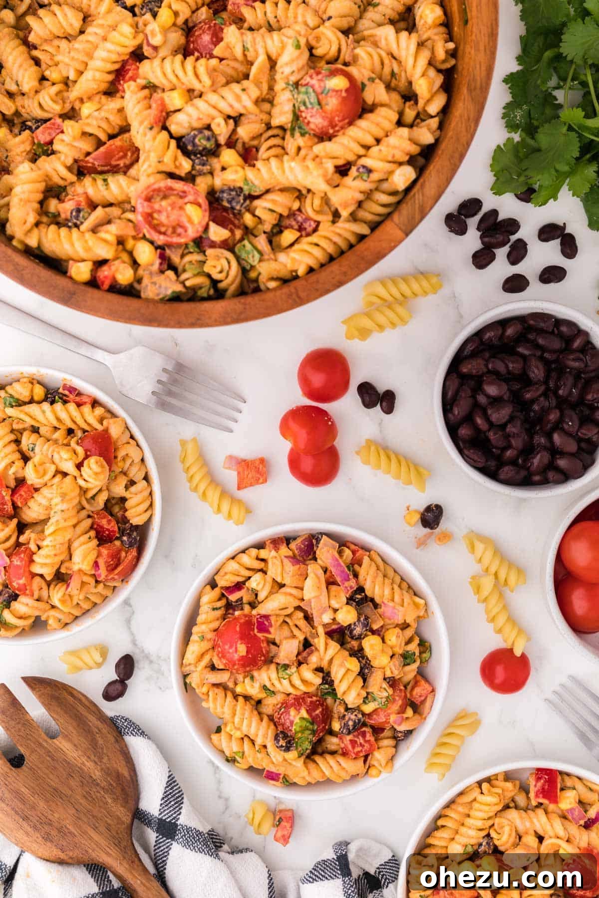 Zesty Fiesta Pasta Salad 11 A serving plate with a portion of southwest pasta salad, showcasing its colorful ingredients and creamy dressing, next to the main serving bowl.