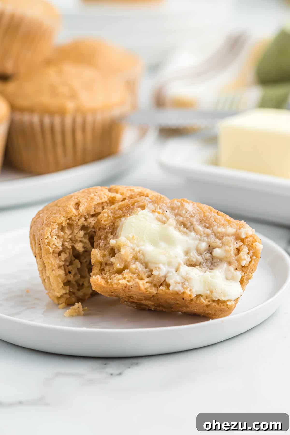 Cinnamon Apple Muffins 13 A perfectly sliced applesauce muffin with butter smeared on its soft interior
