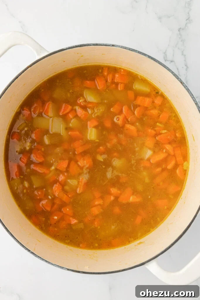 The vegetable soup gently simmering after the successful addition of the milk and flour slurry, showcasing a visibly thickening and creamy texture, promising a delightful rich consistency.