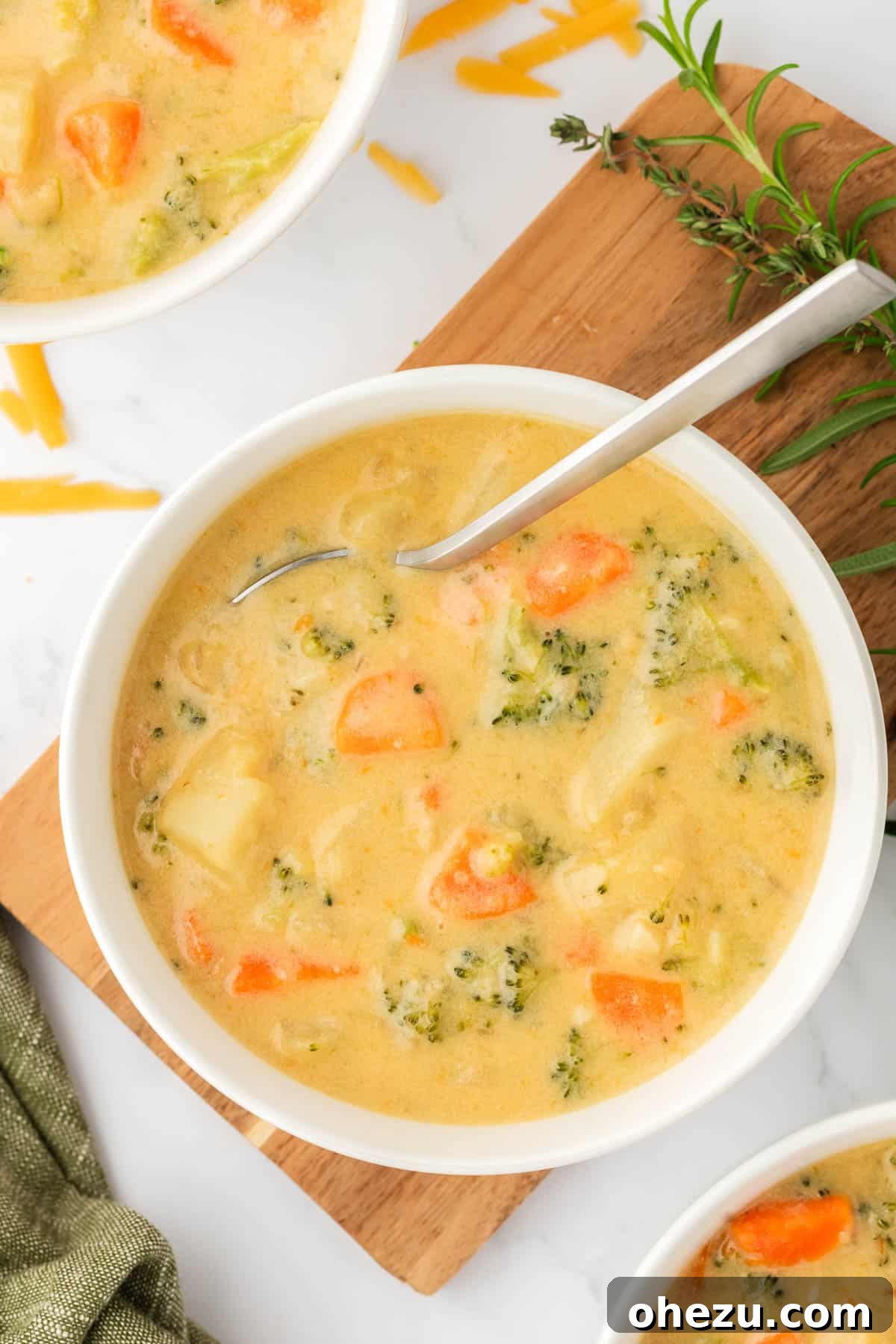A perfectly portioned bowl of creamy vegetable soup, adorned with a spoon, highlighting its inviting texture, vibrant colors, and steaming warmth, ready for immediate enjoyment.