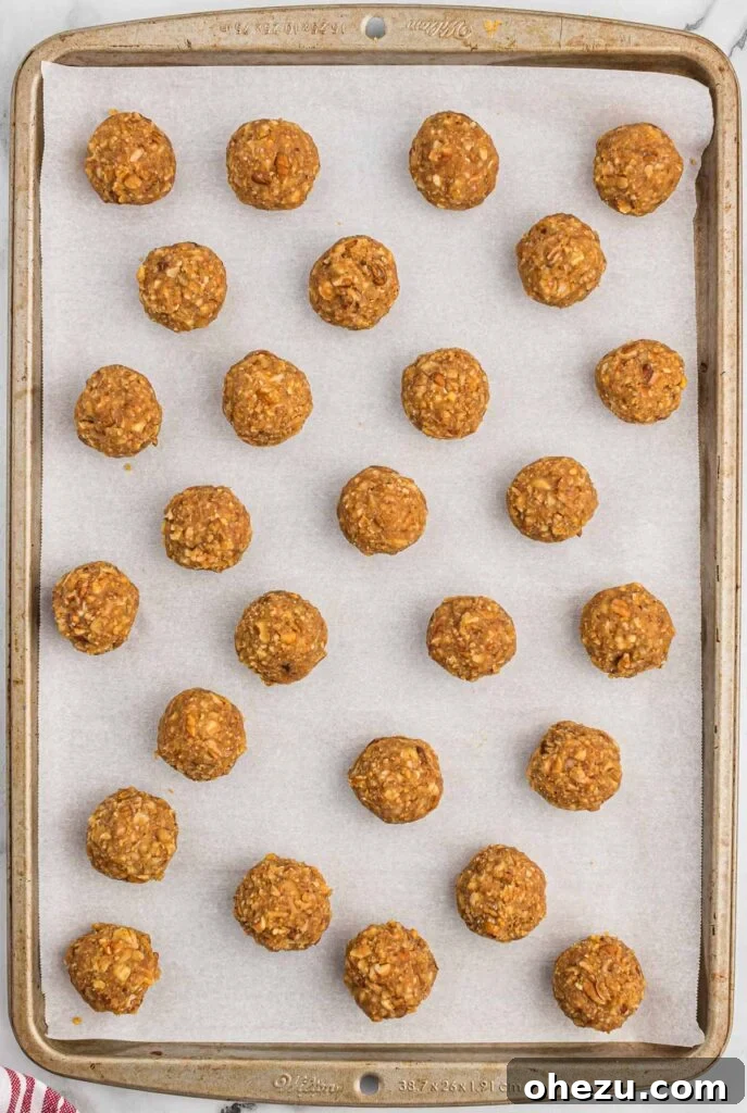 Pecan Pie Truffles 8 Freshly shaped pecan pie balls arranged neatly on a parchment-lined baking sheet before freezing.