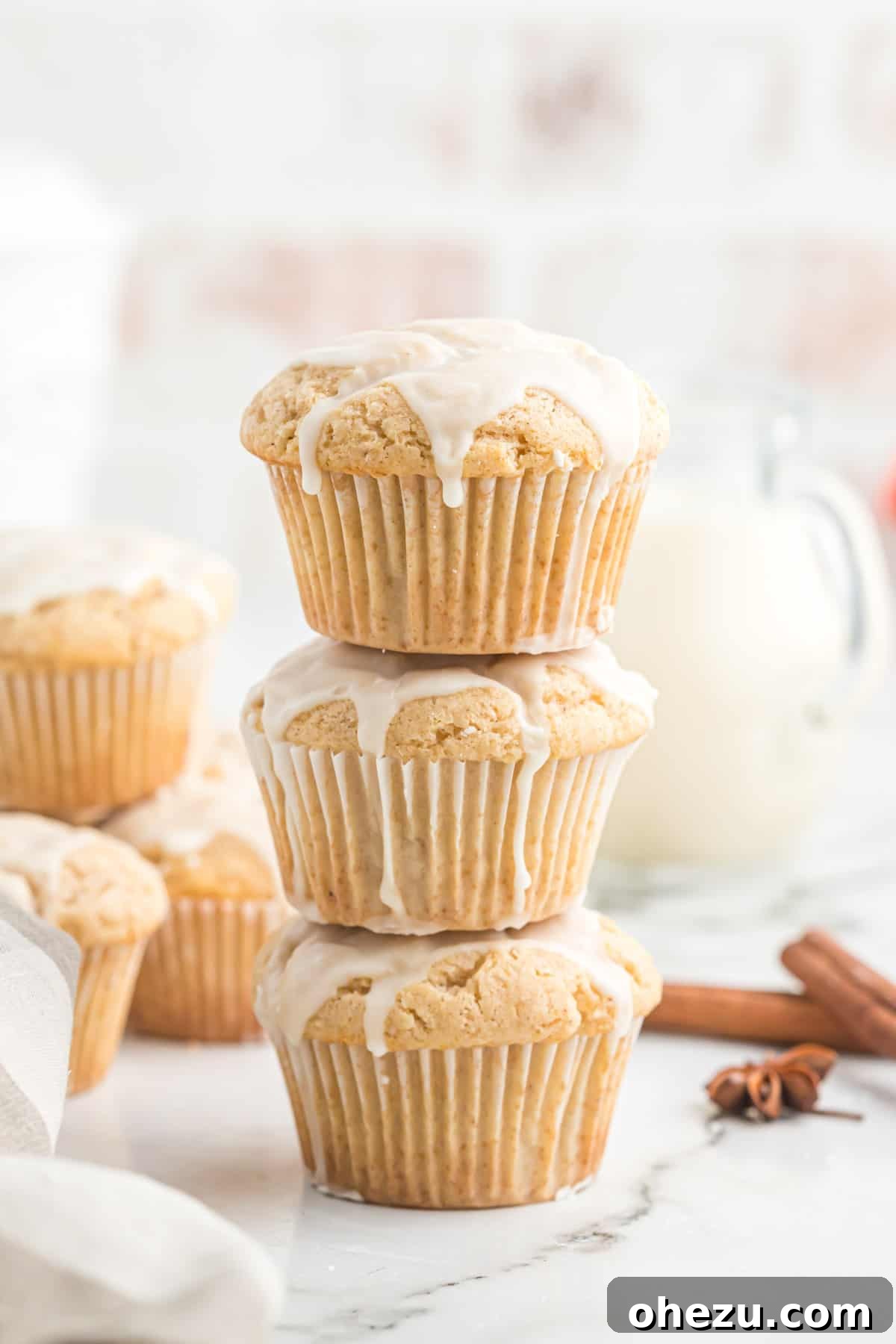 Stacked glazed eggnog muffins, showcasing their fluffy texture and enticing glaze.