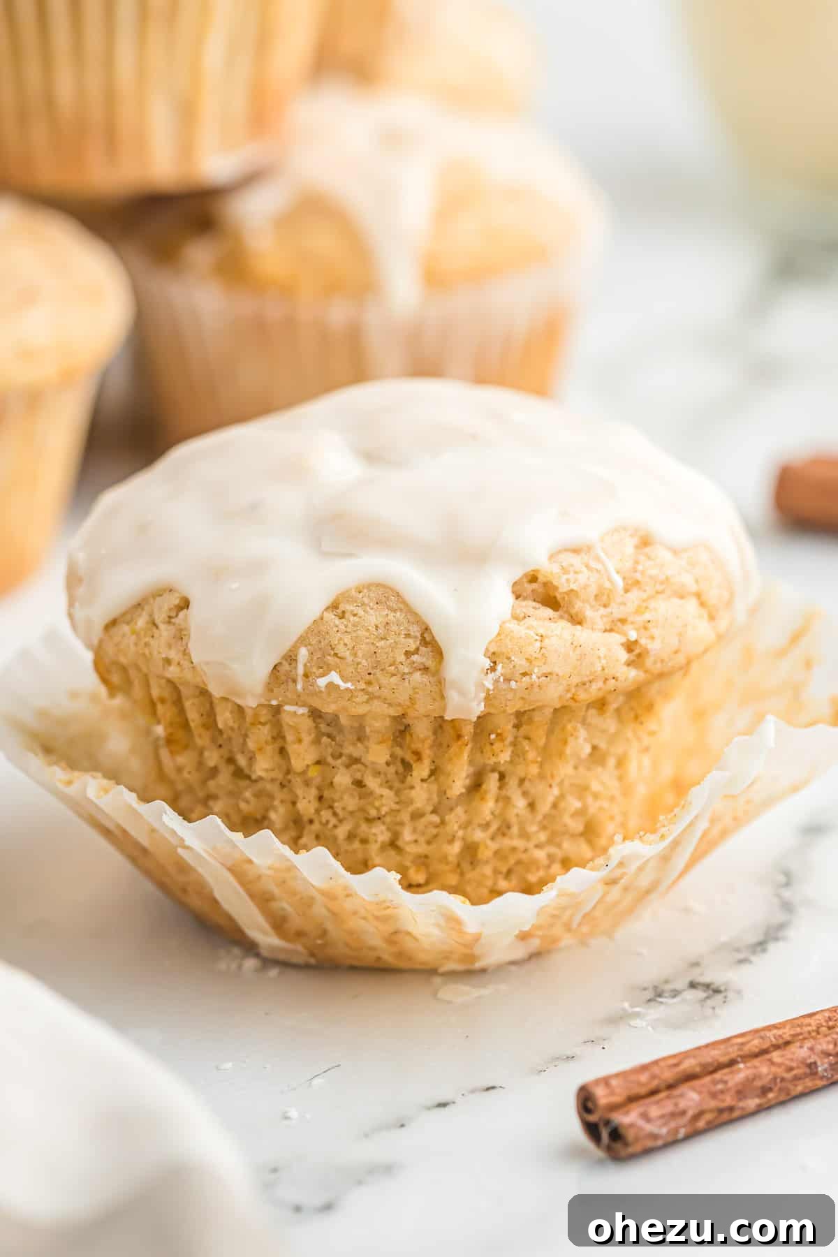 Another view of a single glazed eggnog muffin on a plate, highlighting the delicious glaze.