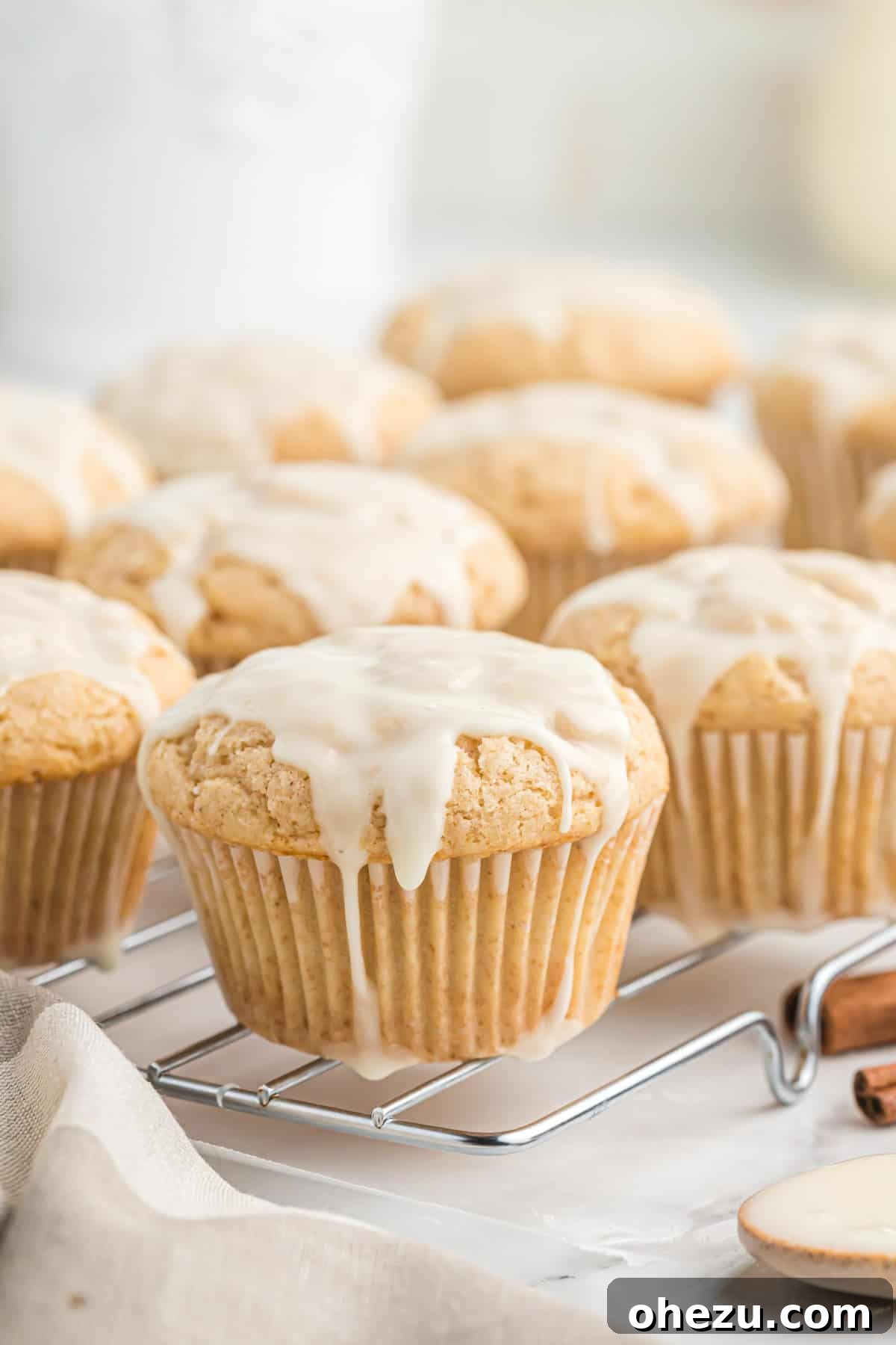 Glazed eggnog muffins cooling on a wire rack, glistening with sweet icing.