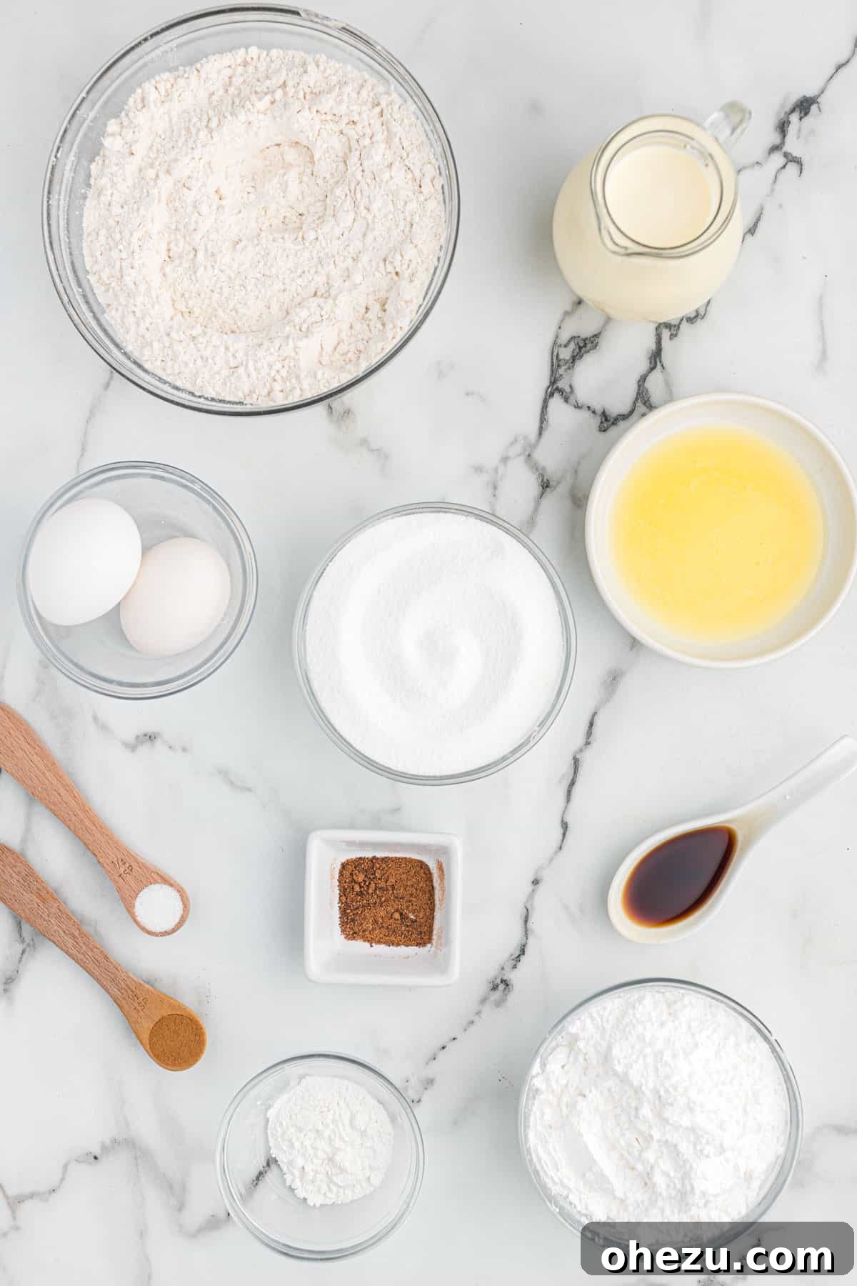 Ingredients laid out on a counter, ready for making eggnog muffins: flour, sugar, eggs, eggnog, butter, and spices.