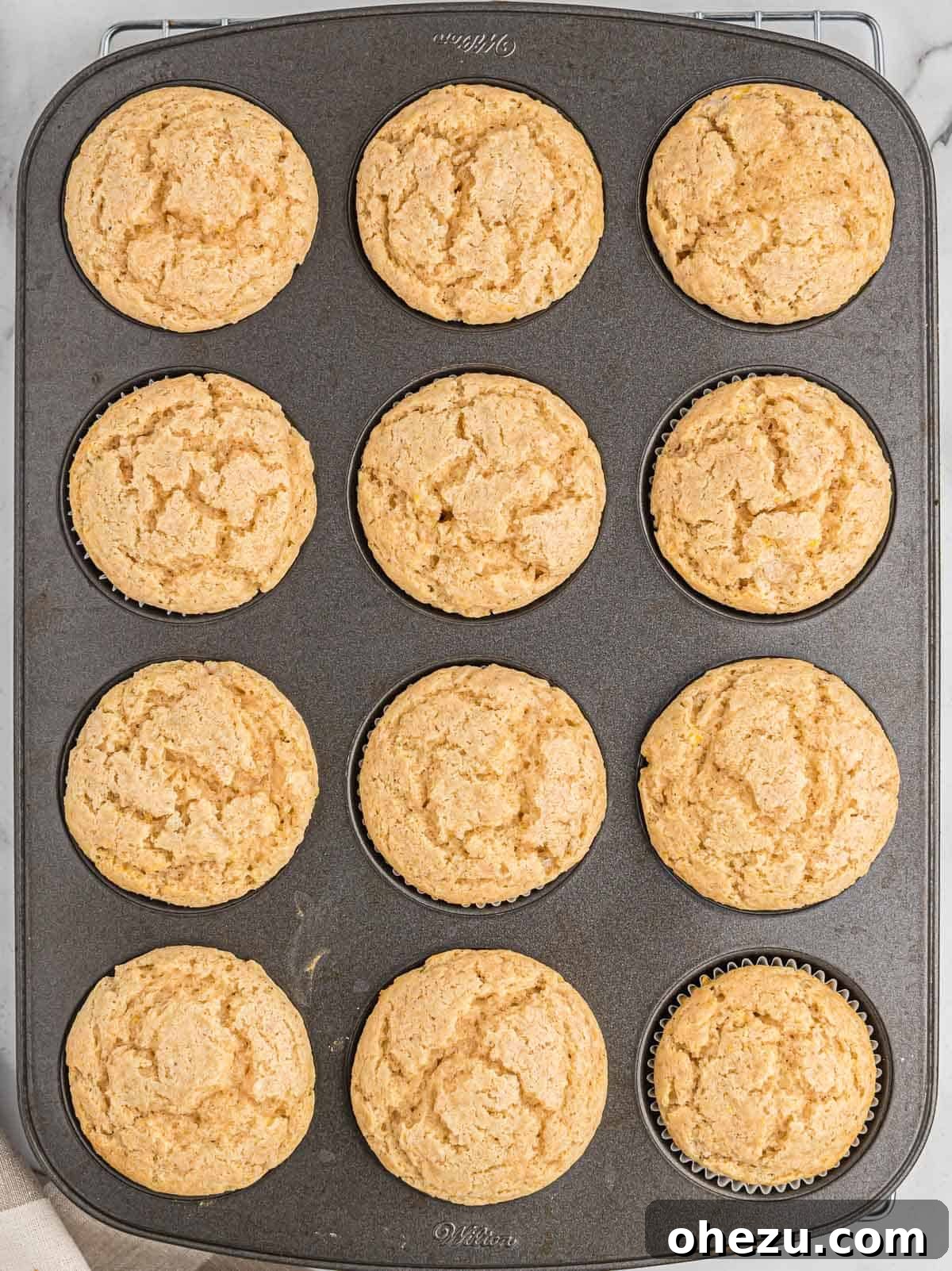 Freshly baked eggnog muffins in a muffin tin, golden and risen.