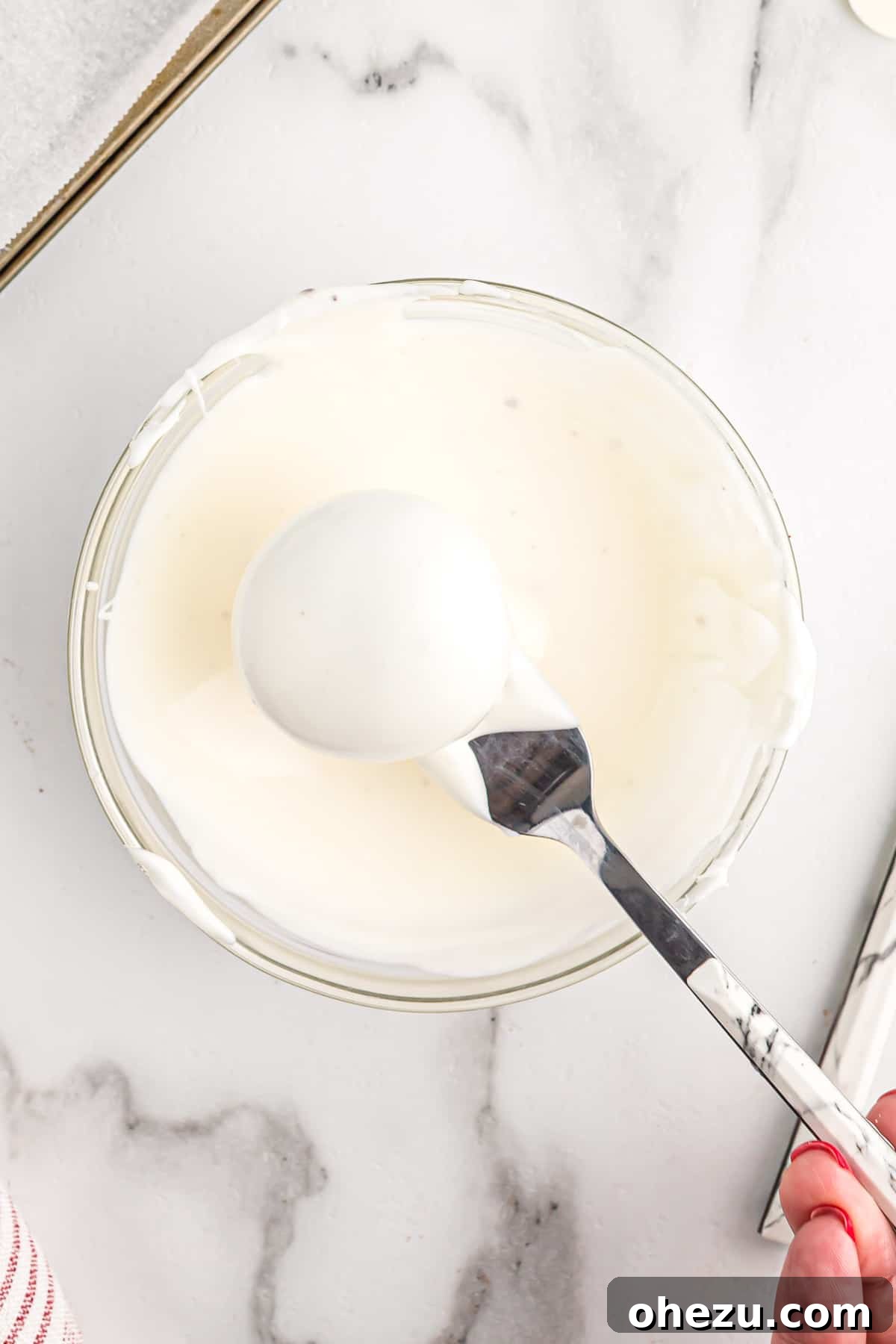 An oreo ball perfectly coated in white chocolate, showcasing a smooth and even finish.