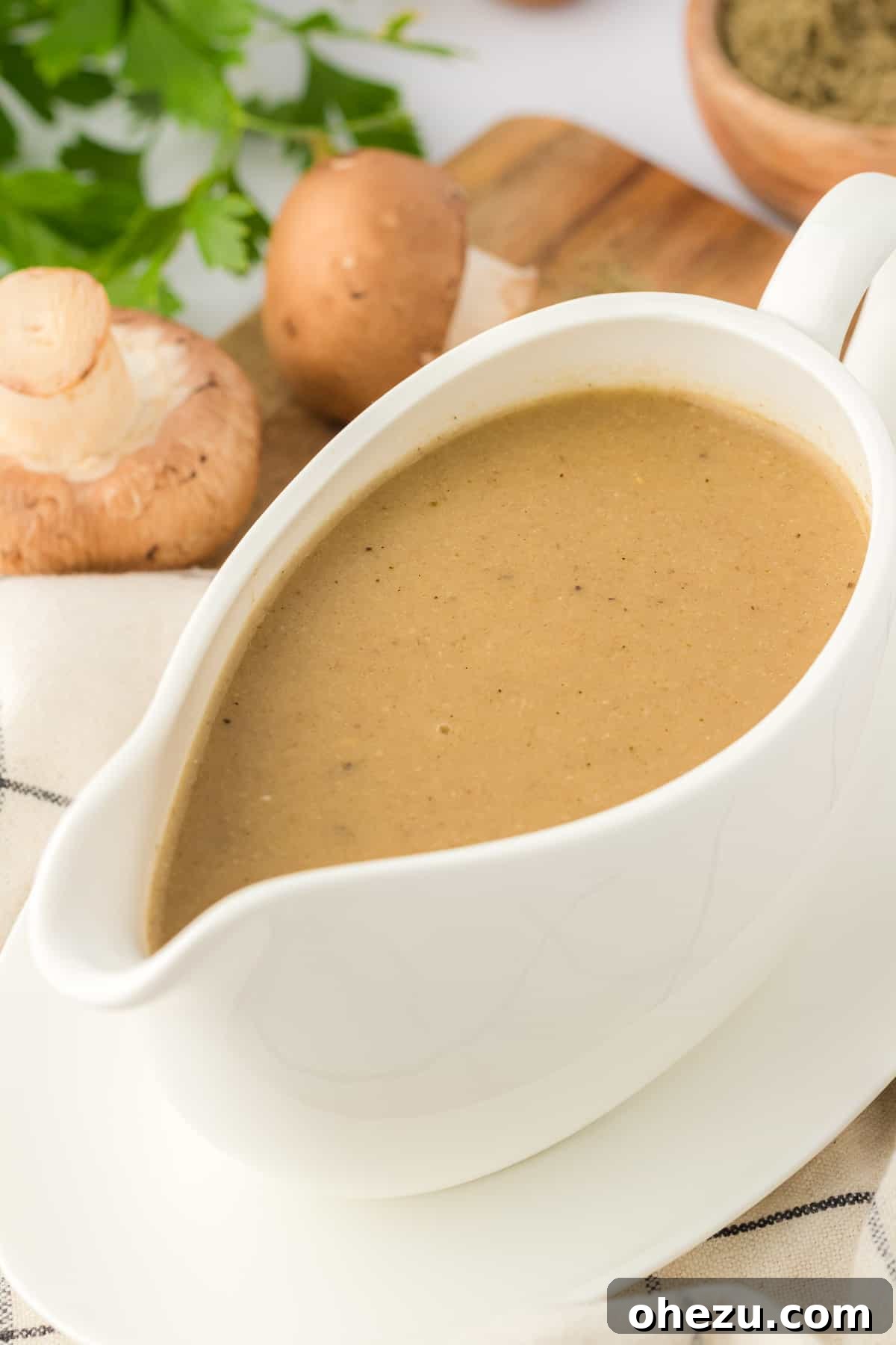 Rich vegetarian gravy poured over fluffy mashed potatoes, ready for a holiday meal.