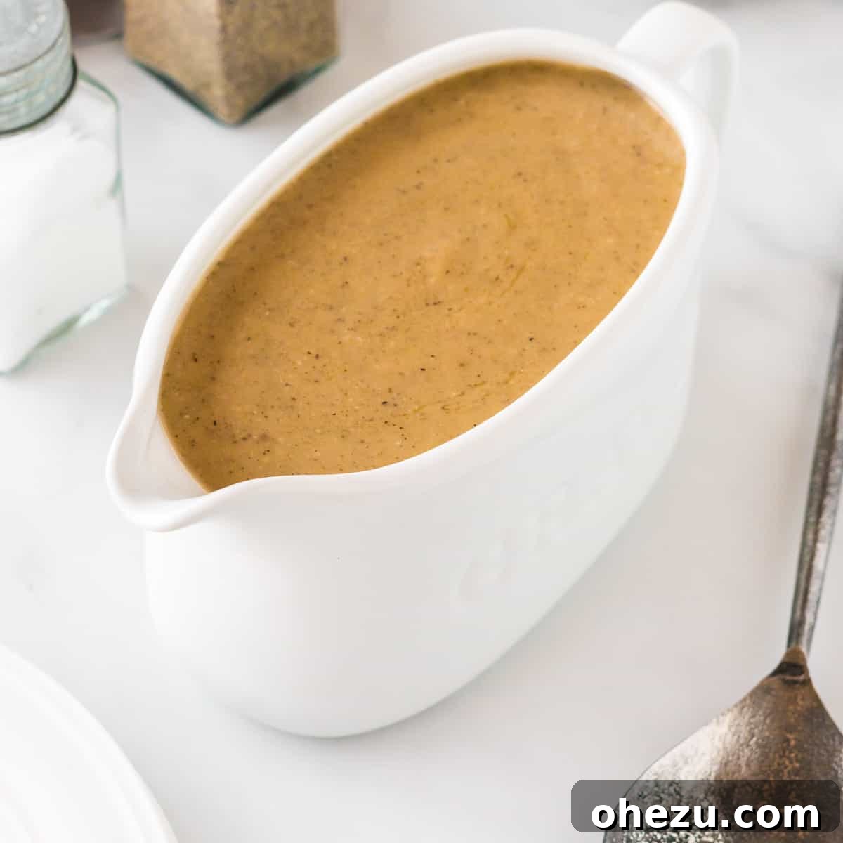 Beautifully textured vegetarian gravy in a pristine white gravy boat, perfectly presented and ready to be served at a holiday feast.