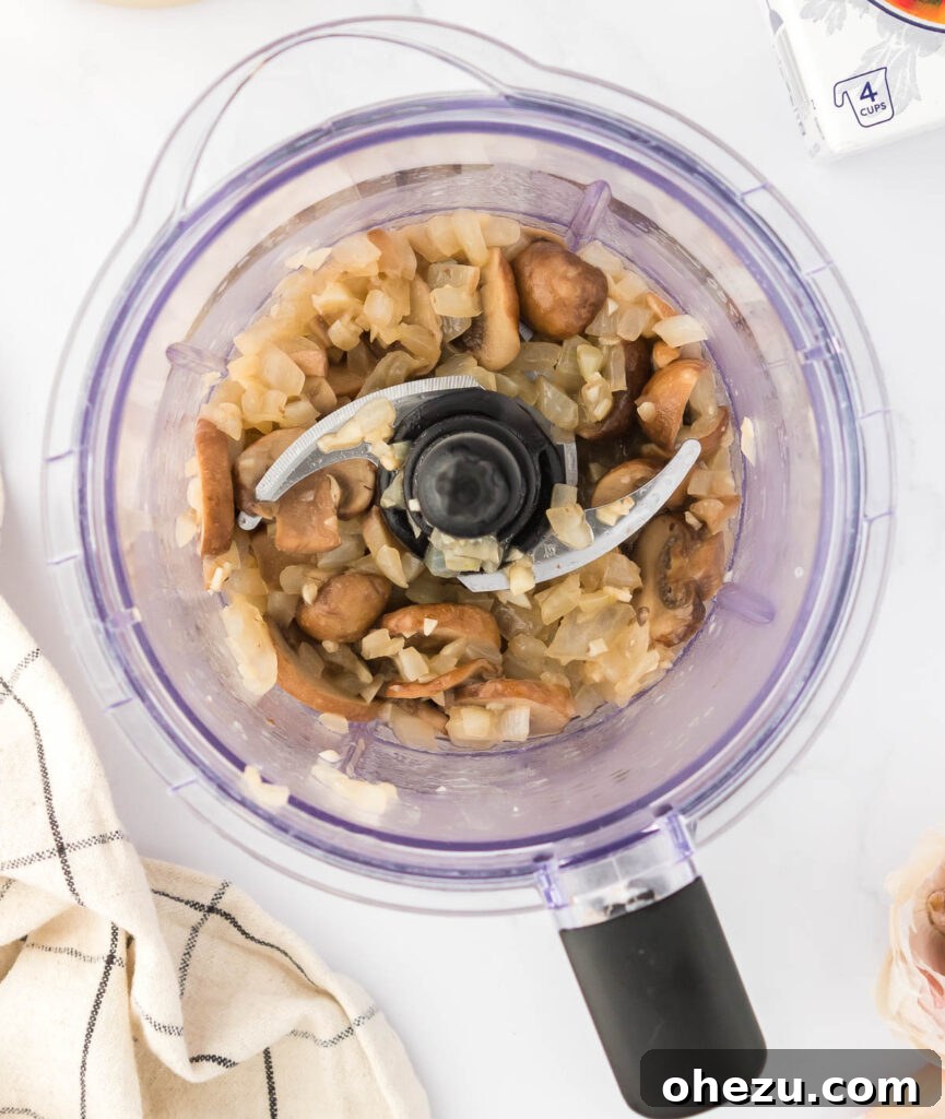 Sautéed mushroom, onion, and garlic mixture carefully placed inside a blender carafe.