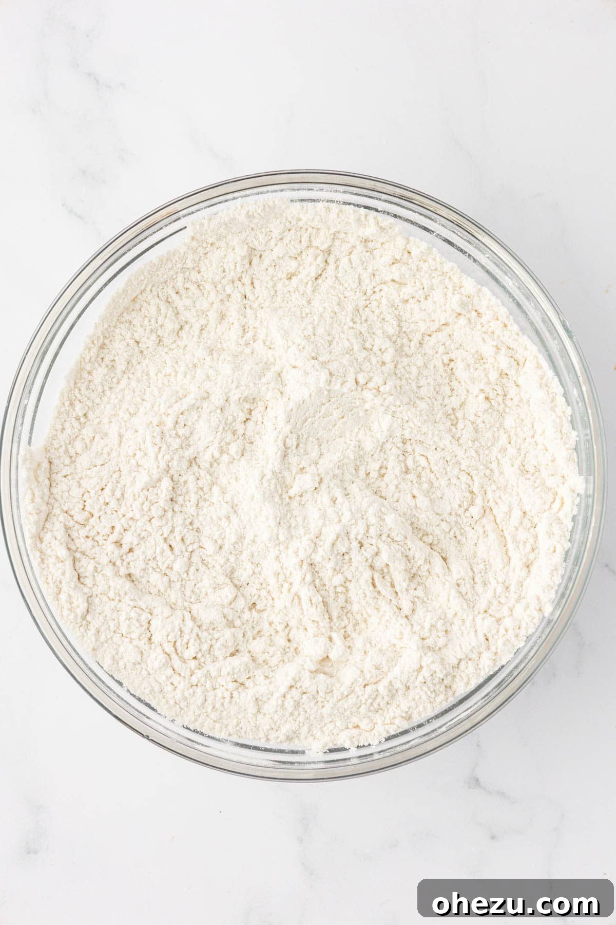 Dry ingredients whisked together in a bowl, creating a uniform powdery mixture.
