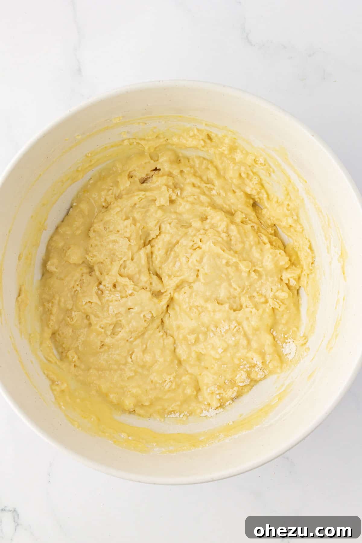 Muffin batter in a bowl after dry and wet ingredients have been combined, showing a slightly lumpy consistency.