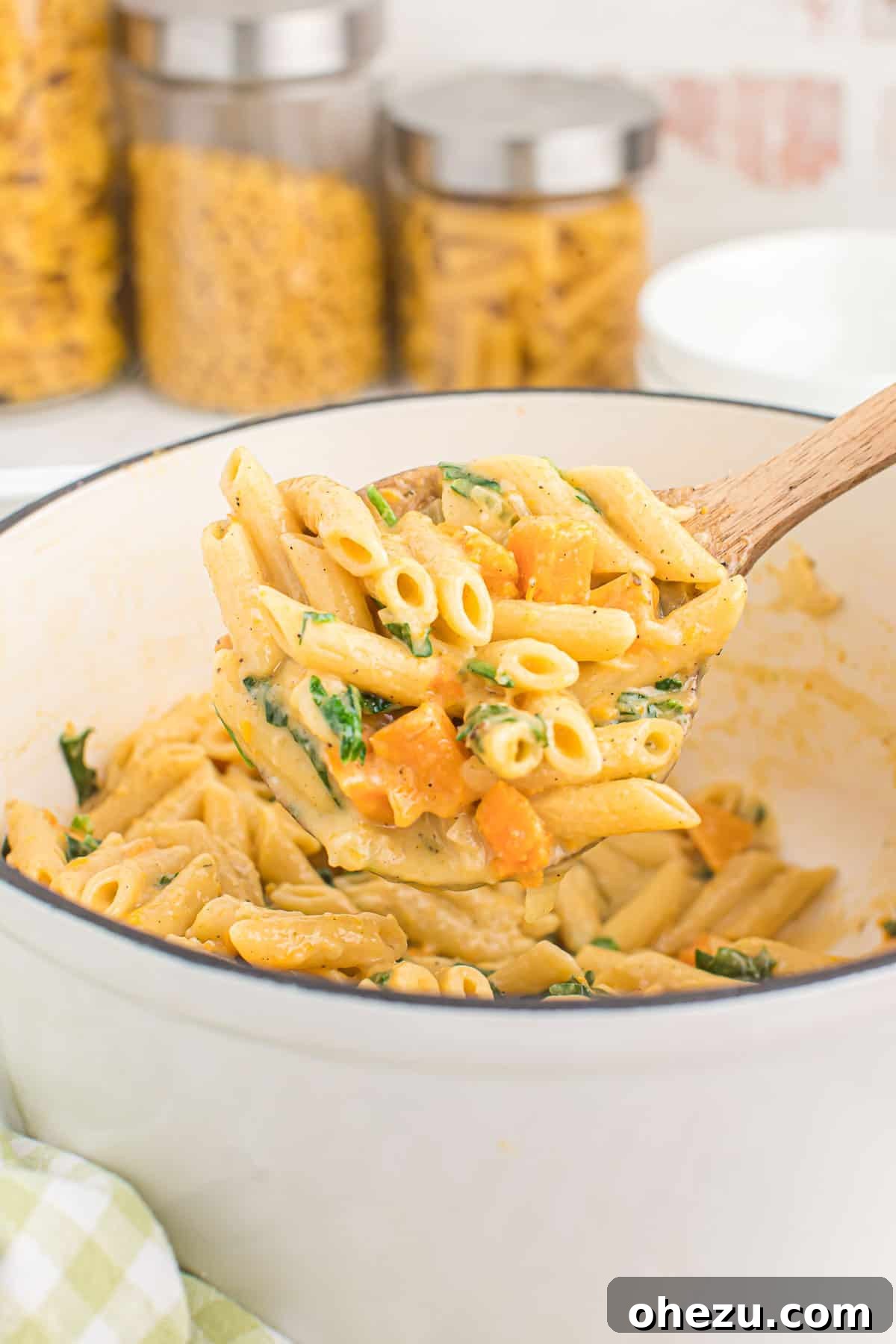 Velvet Sweet Potato Pasta 15 Scooping a generous portion of sweet potato pasta from the Dutch oven, steam rising from the hot meal.