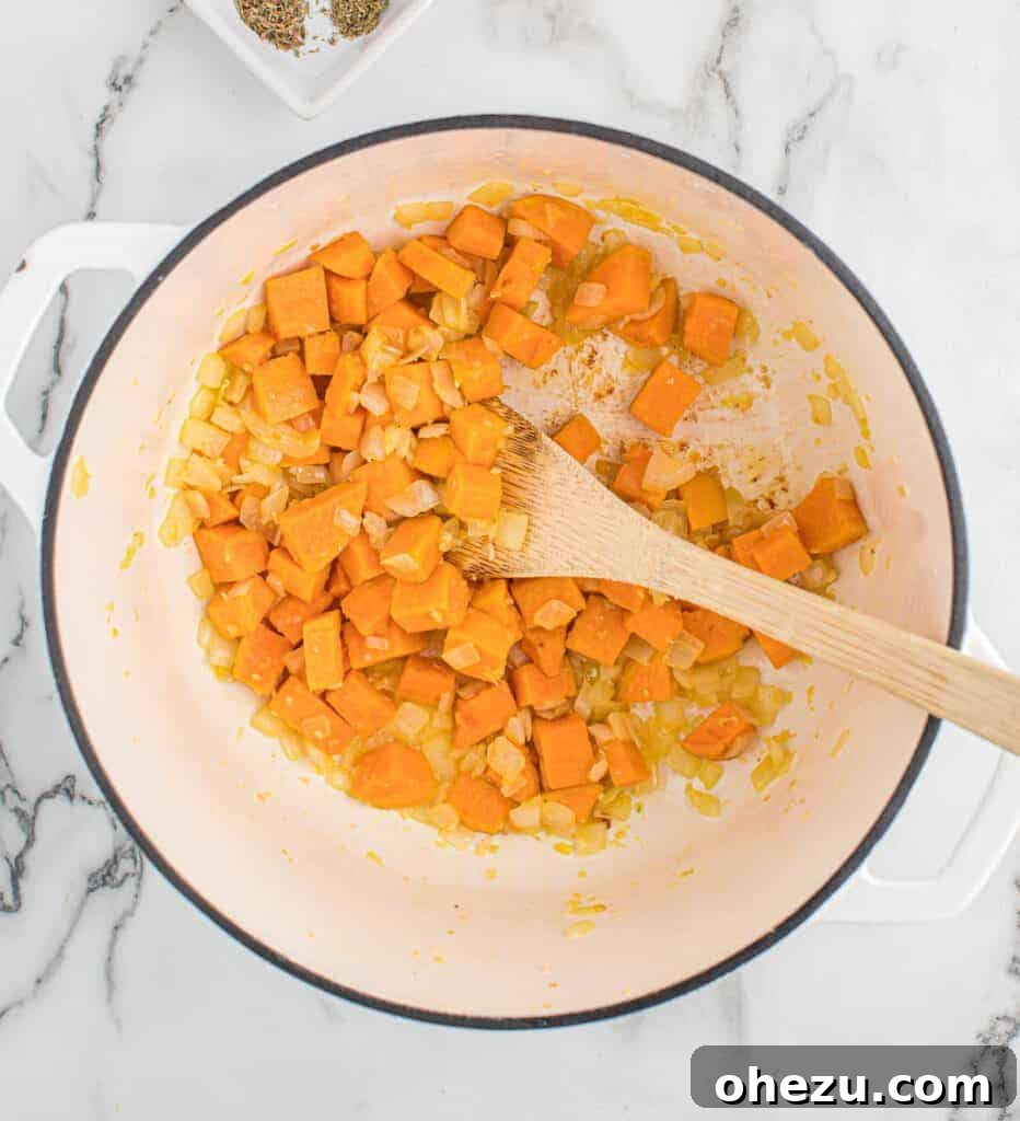 Velvet Sweet Potato Pasta 4 Stirring diced garlic, onion, and sweet potatoes in a large pot, beginning to soften.