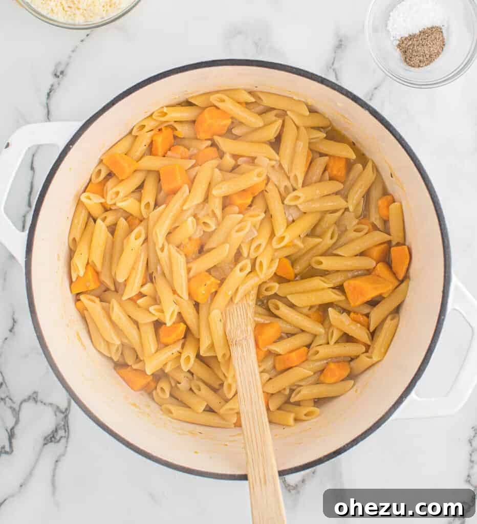 Velvet Sweet Potato Pasta 6 Sweet potato pasta being stirred in the pot as it cooks, absorbing the broth.