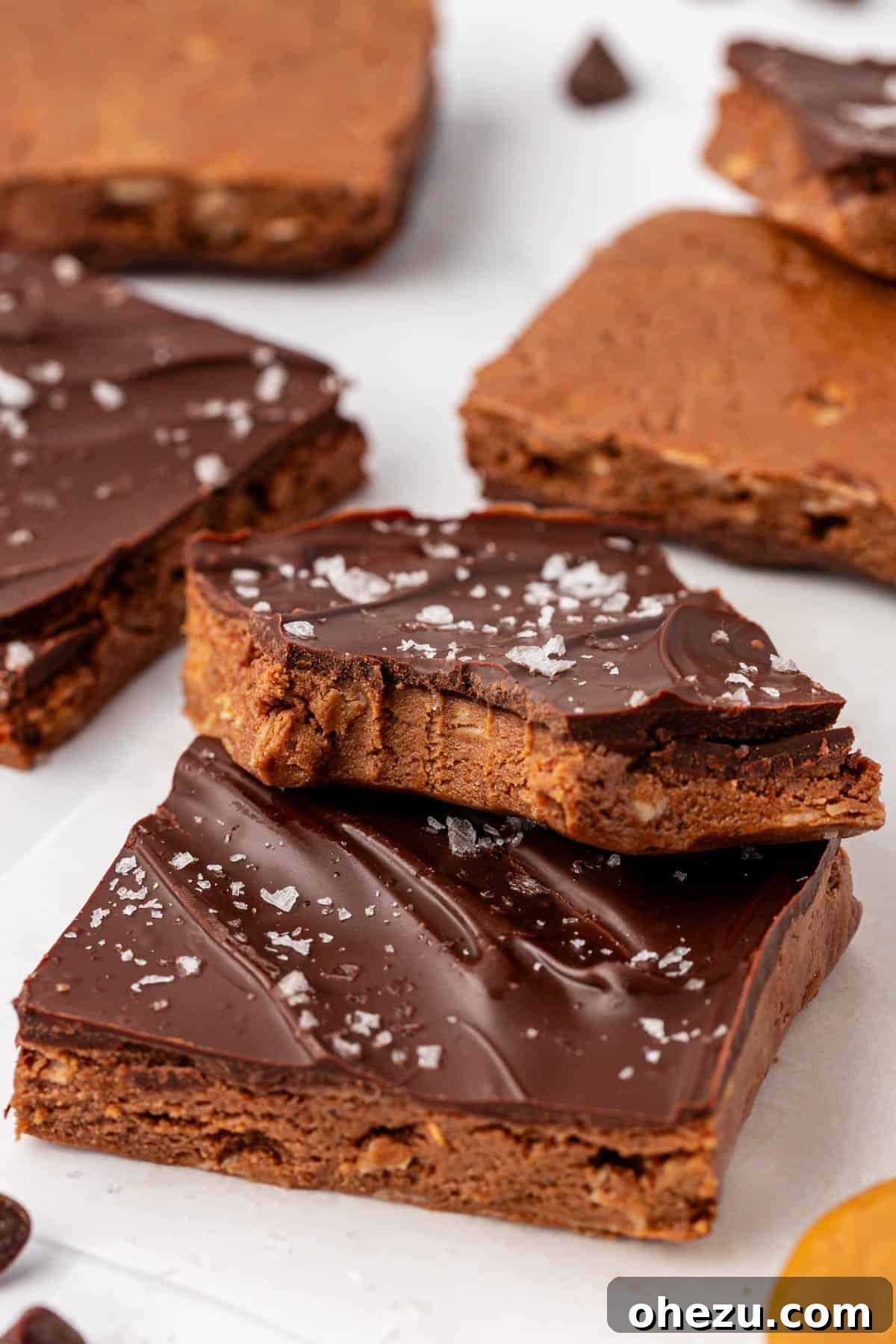 A stack of perfectly cut homemade chocolate protein bars, showcasing their layers and inviting texture.