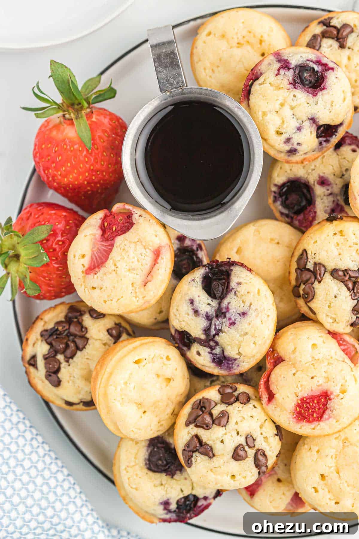 Baked Pancake Bites 12 A small bowl of maple syrup next to a plate of pancake mini muffins, perfect for dipping