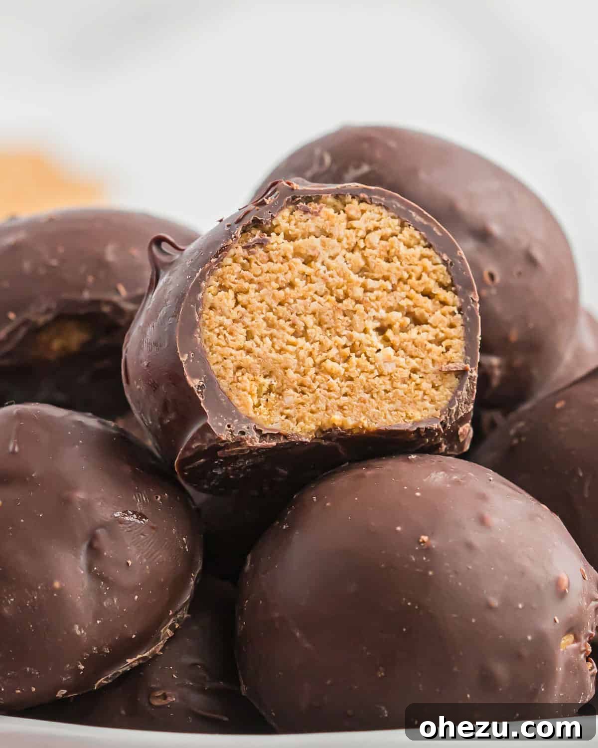 Close-up of freshly made peanut butter balls with graham crackers, showing their smooth, round shape before dipping