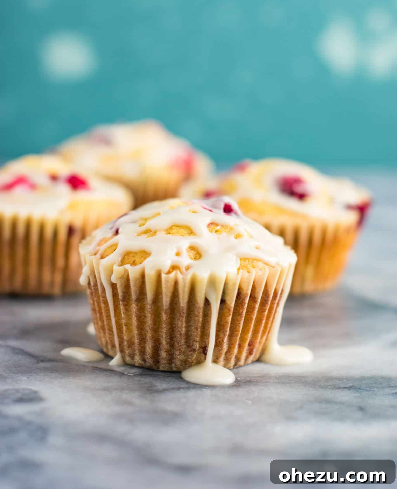 Nine cranberry cream cheese muffins arranged on a rustic wooden surface, perfect for sharing.