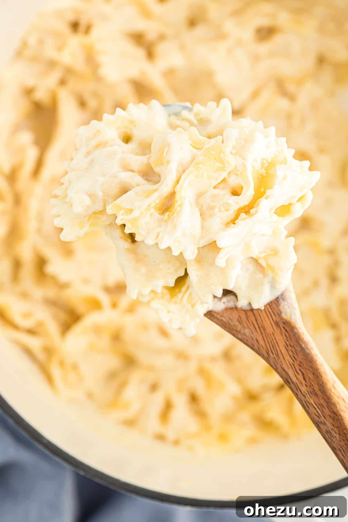 Another vibrant image of Parmesan cream sauce generously covering pasta in a serving bowl.