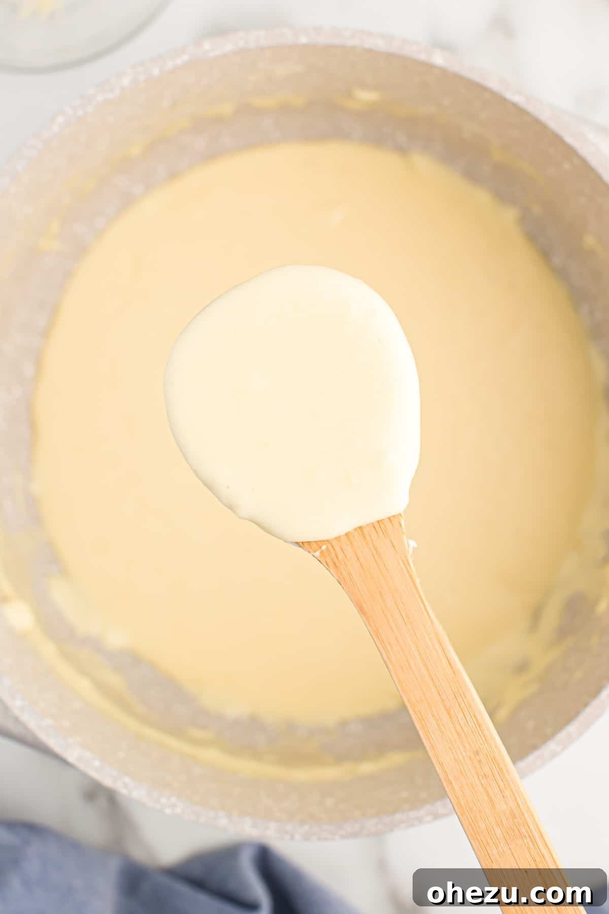 Parmesan cream sauce simmering gently in a sturdy pot on the stove.