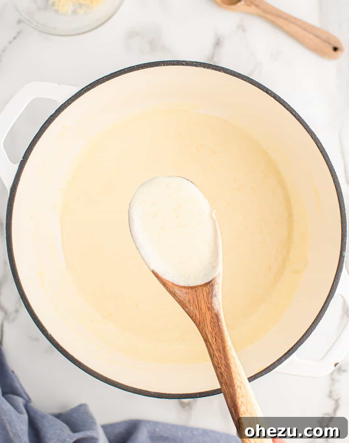 A pan filled with freshly made Parmesan cream sauce, glistening and ready to be served.