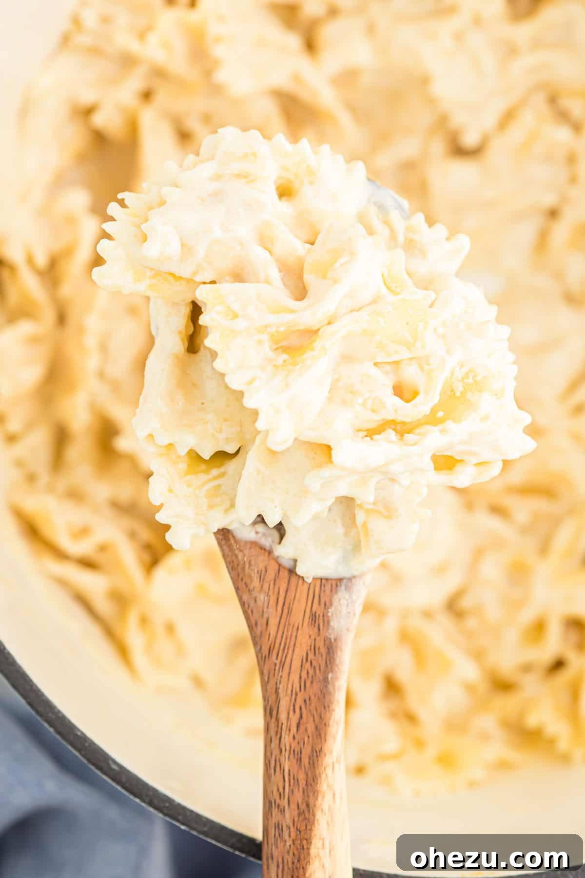 A close-up shot of creamy Parmesan sauce coating pasta in a rustic bowl, garnished with fresh parsley.