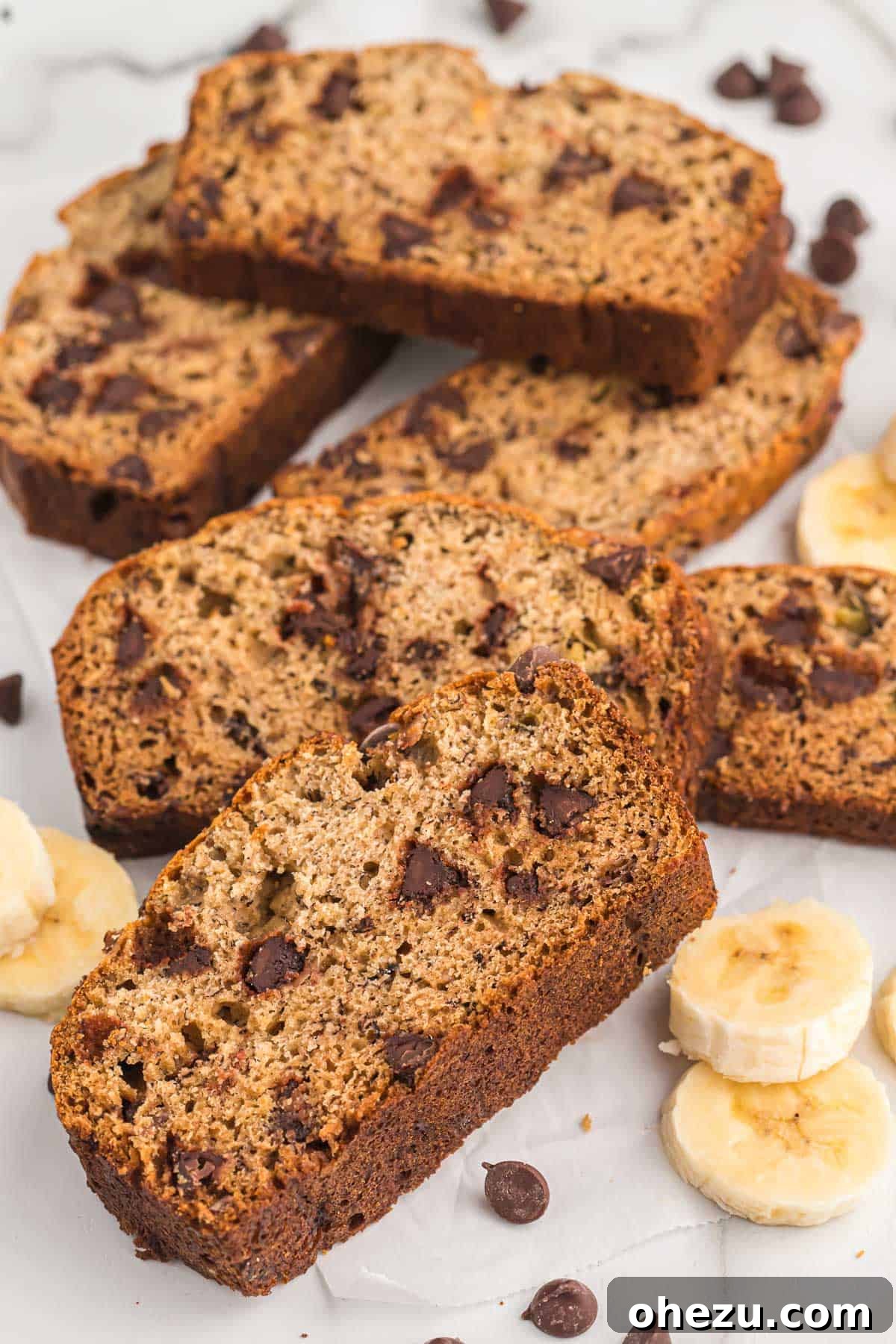 A top-down view of a single, delectable slice of homemade chocolate chip banana bread, highlighting its rich, moist texture and plentiful semi-sweet chocolate chips.