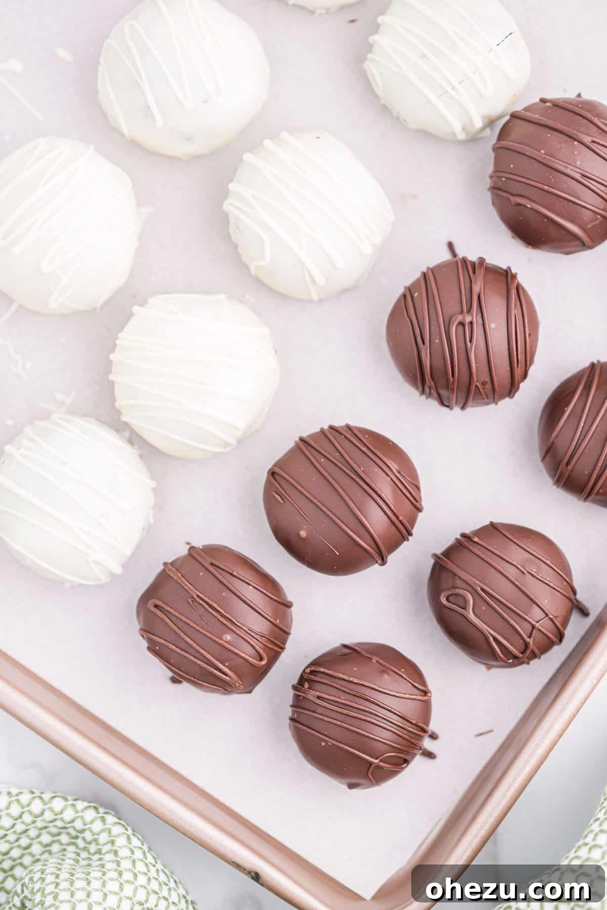 Emerald Oreo Delights 14 A tray of freshly made Mint Oreo truffles, some plain chocolate-coated and others with decorative drizzles, chilling on a baking sheet.
