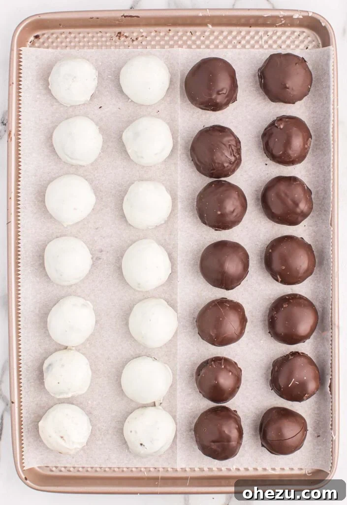 Emerald Oreo Delights 10 A baking sheet filled with a mix of dark and white chocolate-coated Mint Oreo truffles, some already drizzled for decoration, awaiting their final chill.