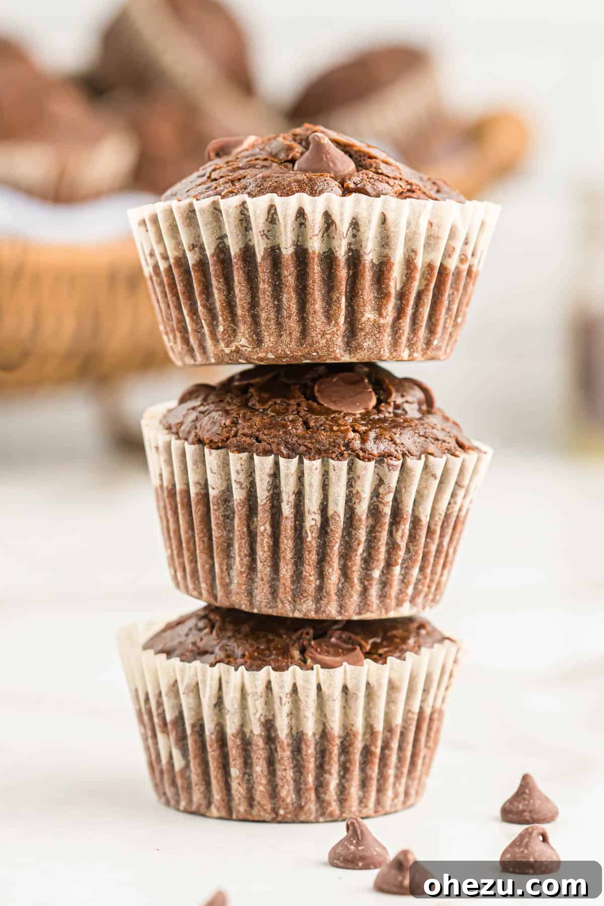 Chocolate Indulgence Muffins 12 A stack of three warm double chocolate muffins, showing their moist interior and melted chocolate chips.
