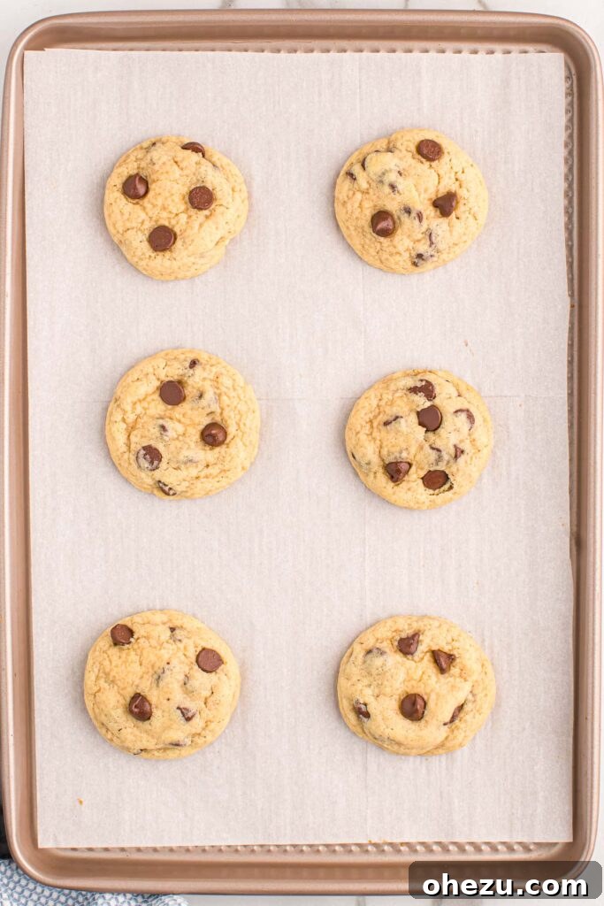 Perfect Chocolate Chip Cookies With No Brown Sugar 17 Cookie dough balls on a baking sheet, each topped with additional chocolate chips, ready to bake