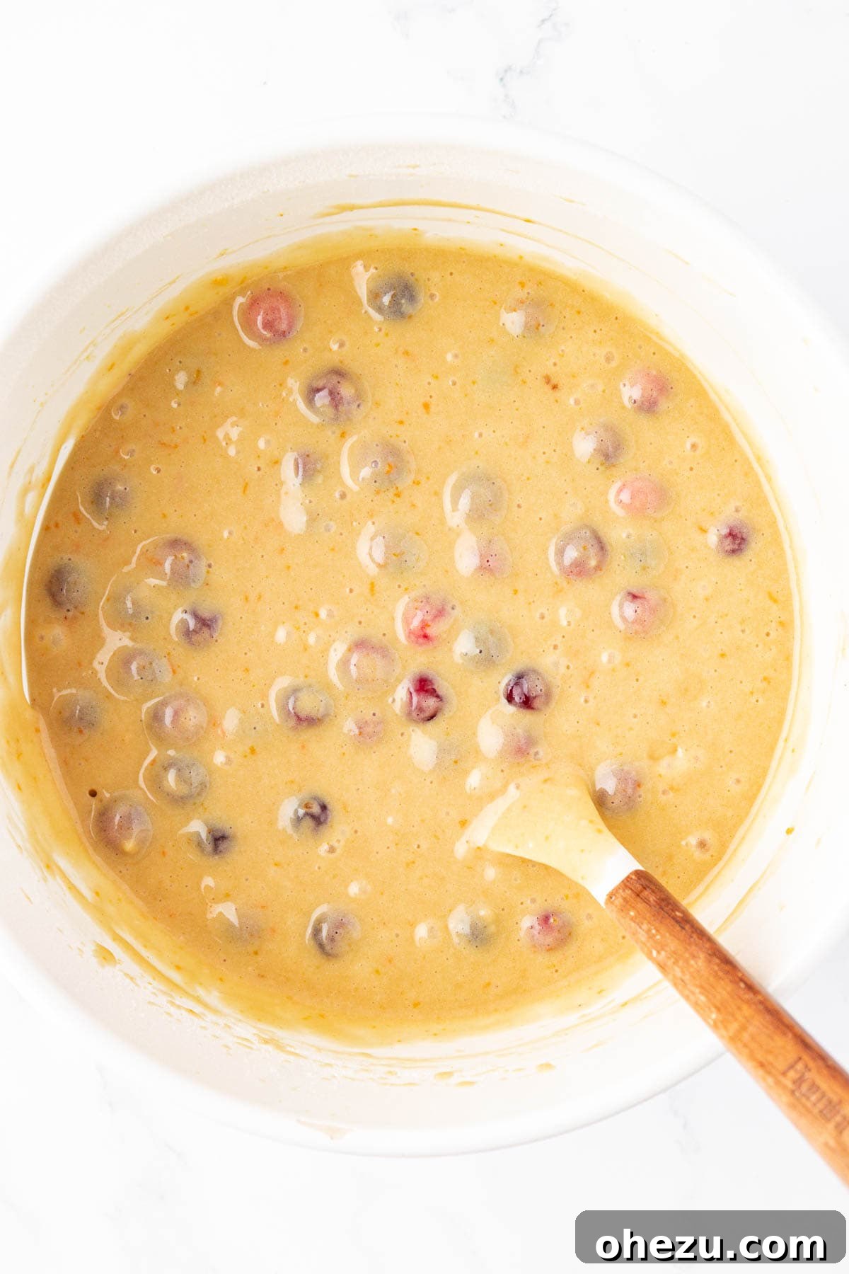 Cranberry bread batter with fresh cranberries evenly distributed, ready for the loaf pan.