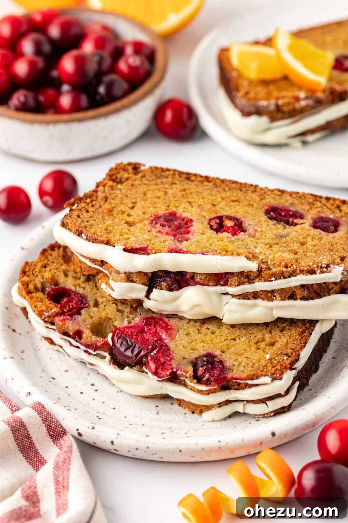 Another perspective of the cranberry eggnog bread, highlighting its festive appearance and white chocolate drizzle.