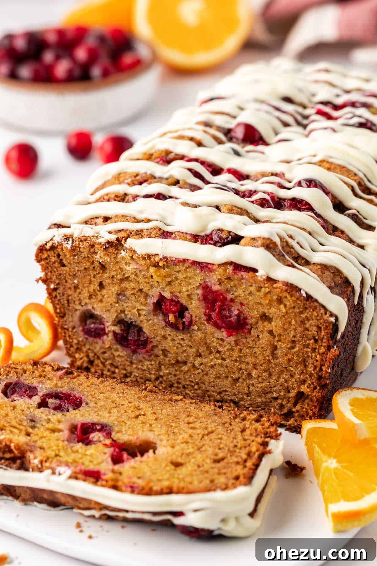 A perfectly sliced piece of cranberry eggnog bread with white chocolate, showcasing its moist interior and fruit.